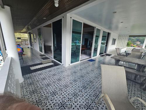 a screened in porch with a table and chairs at Castle Villa Phuket in Kamala Beach
