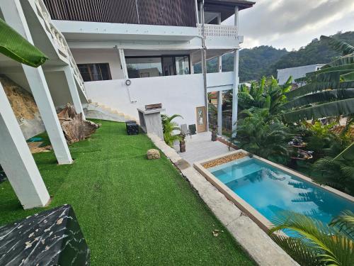 a house with a yard with a swimming pool at Castle Villa Phuket in Kamala Beach