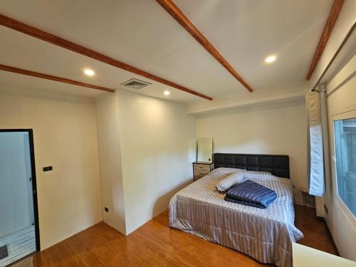 a bedroom with a bed and a window at Castle Villa Phuket in Kamala Beach