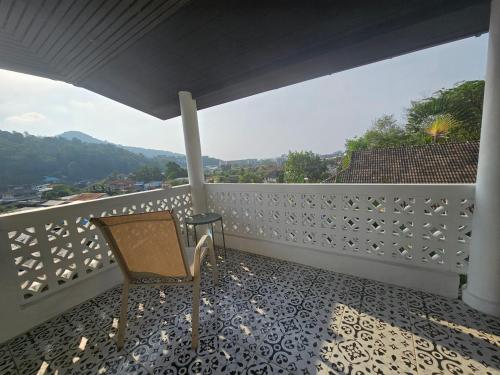 a balcony with a chair and a table and a view at Castle Villa Phuket in Kamala Beach