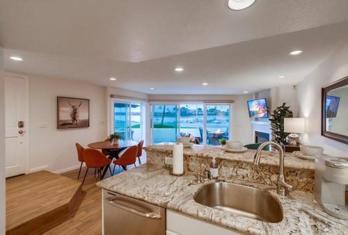 a kitchen with a sink and a table with chairs at Jamaica Sands in San Diego