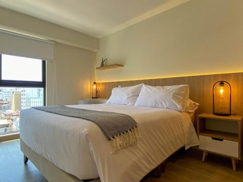 a bedroom with a large white bed with a window at Pod by Wynwood House in Lima