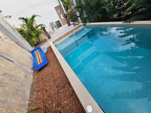 a blue swimming pool with a chair next to it at Castle Villa Phuket in Kamala Beach
