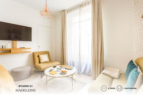 ein weißes Wohnzimmer mit einem Tisch und einem Stuhl in der Unterkunft Beauquartier - Madeleine in Paris
