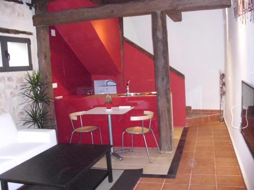 a kitchen with red walls and a table and chairs at Casa Rural con Jacuzzi La Dulce in Cabañas de Polendos