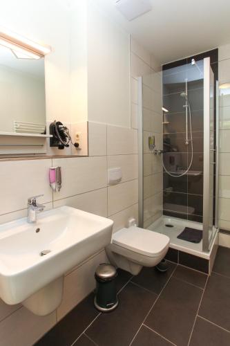 a bathroom with a sink and a toilet and a shower at Restaurant & Pension Eshramo in Barth