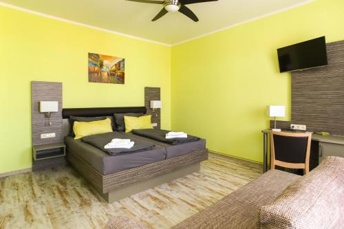 Schlafzimmer mit einem Bett und einem Flachbild-TV in der Unterkunft Restaurant & Pension Eshramo in Barth