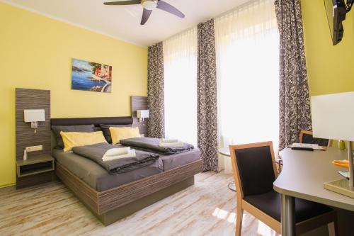 a bedroom with a bed and a desk at Restaurant & Pension Eshramo in Barth
