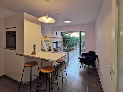 une cuisine avec une table et des chaises dans une pièce dans l'établissement Jardin, terrasse, climatisation, à 5 minutes à pied des plages, commerces et animations, à Saint-Mandrier-sur-Mer
