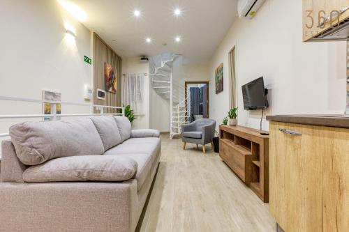 a living room with a couch and a tv at Authentic & Spacious 3BR home with Private Terrace by 360 Estates in Rabat