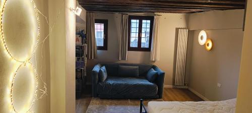 a living room with a blue chair in a room at Piccola Perla sul Canale in Venice
