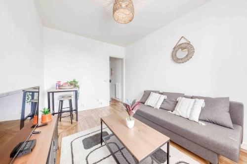 a living room with a couch and a table at Appartement cosy au calme, proche de Paris et du RER B in Gentilly