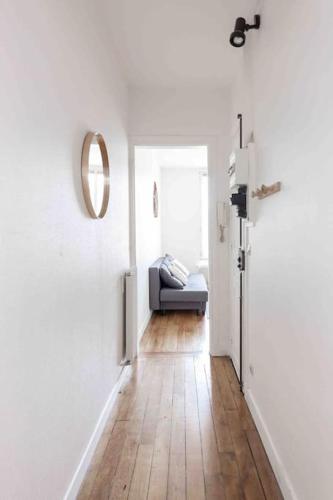 a hallway with a couch in a white room at Appartement cosy au calme, proche de Paris et du RER B in Gentilly