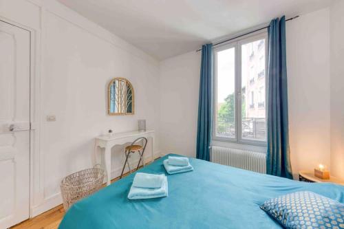 a bedroom with a blue bed and a window at Appartement cosy au calme, proche de Paris et du RER B in Gentilly