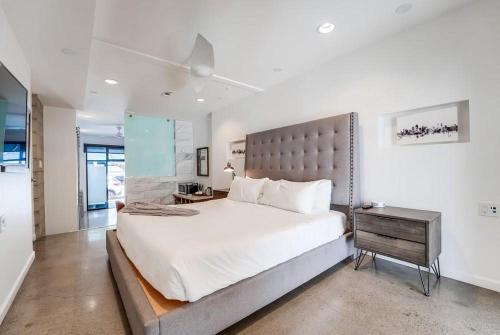 a white bedroom with a large bed and a table at Kettner Row 1 in San Diego