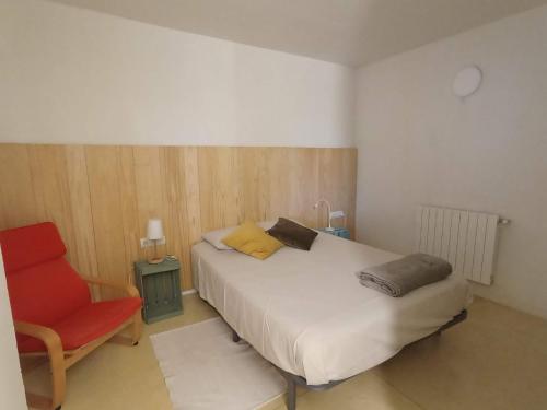 班約萊斯的住宿－Travertí de Banyoles，一间卧室配有一张床和一张红色椅子