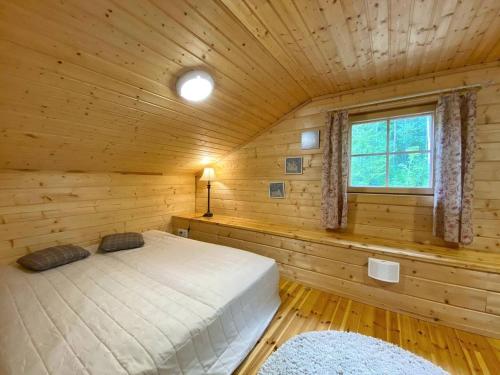 a bedroom with a bed in a wooden cabin at Beautiful and spacious lakeside cottages in Imatra