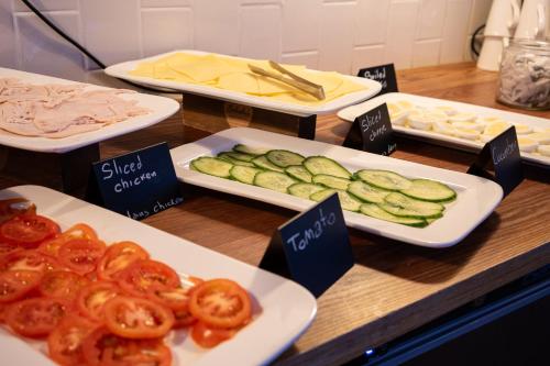 a table topped with plates of tomatoes and cucumbers at St Christopher's Inn Hammersmith in London