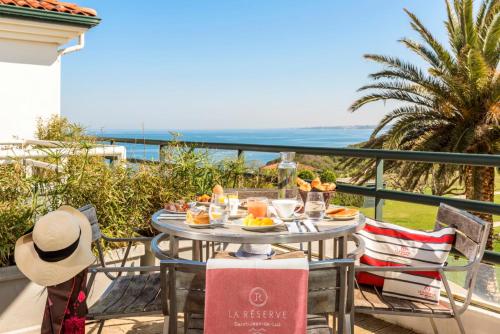 a table with food and a view of the ocean at Hôtel La Réserve in Saint-Jean-de-Luz