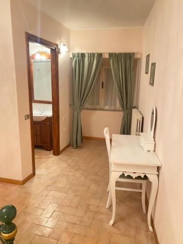 um quarto com uma mesa e cadeiras e um lavatório em Appartamento San Sisto n 8 em Spello