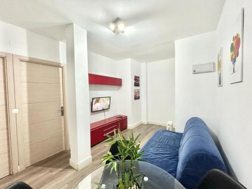 a living room with a blue couch and a glass table at Madrid Rio Antonio Lopez A in Madrid