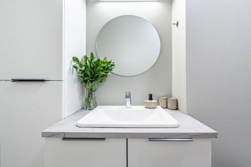 un bagno bianco con lavandino e specchio di Astro Laugavegur a Reykjavik