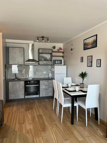 cocina y comedor con mesa y sillas en Baltic Apartament en Liepāja