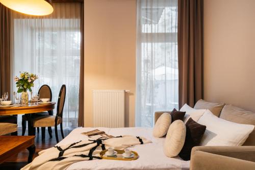 Topolowa Residence - LoftAffair Collection في كراكوف: غرفة نوم مع سرير وطاولة مع غرفة طعام