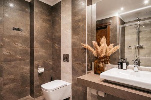 a bathroom with a toilet and a sink at Topolowa Residence LoftAffair Collection in Kraków