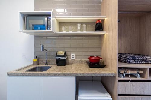 a kitchen with a sink and a counter top at 360 Suítes Sé in Sao Paulo