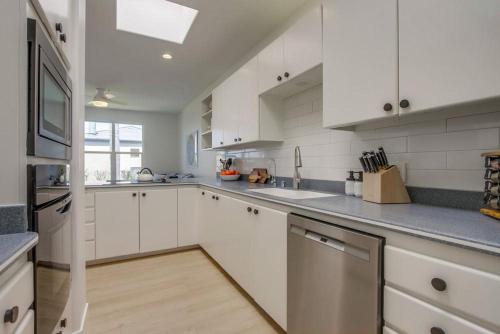a white kitchen with white cabinets and a sink at Ocean Oasis in Encinitas