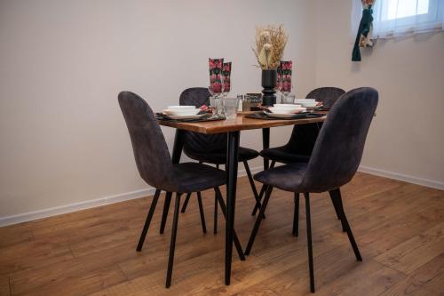 a dining room table with four chairs and a table at Studio apartman Daruvar in Daruvar