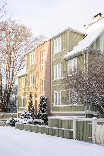 a house with snow on the ground in front of it at Videviku Villa Apartments in Tallinn