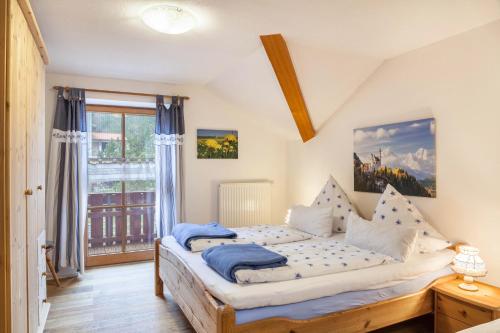 1 dormitorio con cama y ventana en Ferienwohnung Mair - Sonnaufgang, en Halblech