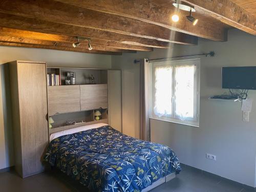 een slaapkamer met een bed en een raam bij Domisiladore in Latouille-Lentillac