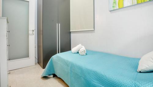 a bedroom with a blue bed with towels on it at Cozy Room St Julian's in Il-Gżira