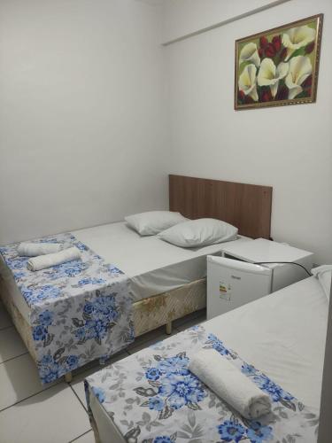een kamer met twee bedden en een foto aan de muur bij HOTEL DIVINO PAI ETERNO 2 in Aparecida