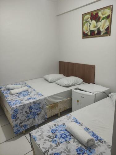 a room with two beds and a picture on the wall at HOTEL DIVINO PAI ETERNO 2 in Aparecida