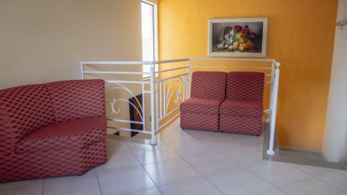 two chairs in a room with a painting on the wall at Pousada São Nicolau in Cachoeira Paulista