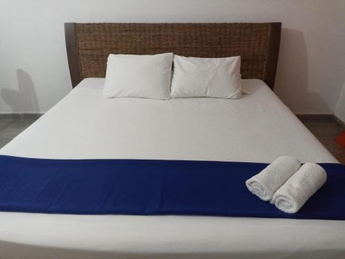 Una cama con dos toallas encima. en CABAÑAS CAMPESTRES LA AURORA DEL LLANO, en Villavicencio