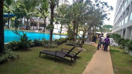 a group of people walking down a sidewalk next to a pool at Laguna Beach Resort 3 The Maldives in Jomtien Beach