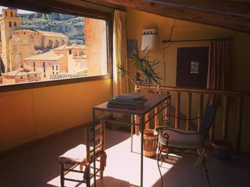 Zimmer mit einem Tisch, einem Stuhl und einem Fenster in der Unterkunft Casa de Santiago in Albarracín