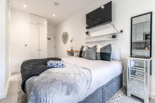 een slaapkamer met een groot bed en een flatscreen-tv bij Livestay Tranquil Studio Retreat in Harrow in Harrow