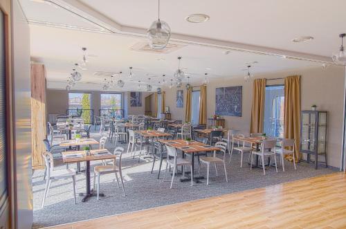 un comedor con mesas, sillas y ventanas en Tulip Inn Żyrardów, en Żyrardów