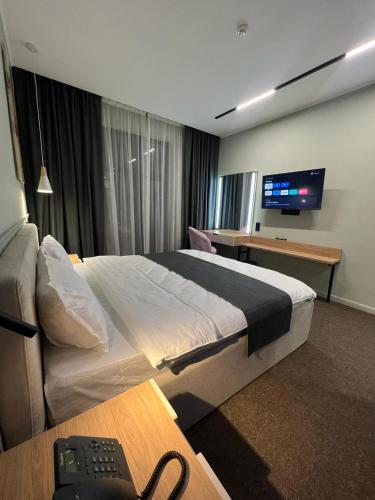 una camera d'albergo con un grande letto e una TV di Caspian Marine Hotel ad Aqtau