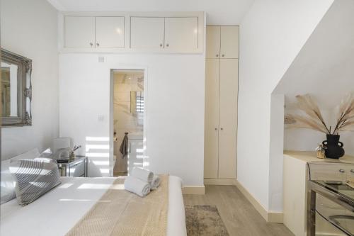 een woonkamer met witte muren en een keuken bij Livestay Tranquil Studio Retreat in Harrow in Harrow