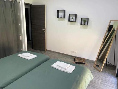 une chambre avec un lit avec deux serviettes dessus dans l'établissement La Villa Cirindinu, à Cirendinu