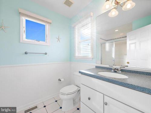een witte badkamer met een wastafel en een toilet bij Holder D in Beach Haven