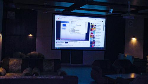 a large projection screen in a room with chairs at Sangam Hotel Marriage Garden & Restaurant in Chirāwa