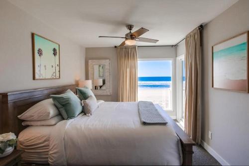 a bedroom with a bed and a window with the beach at Salt Life in San Diego